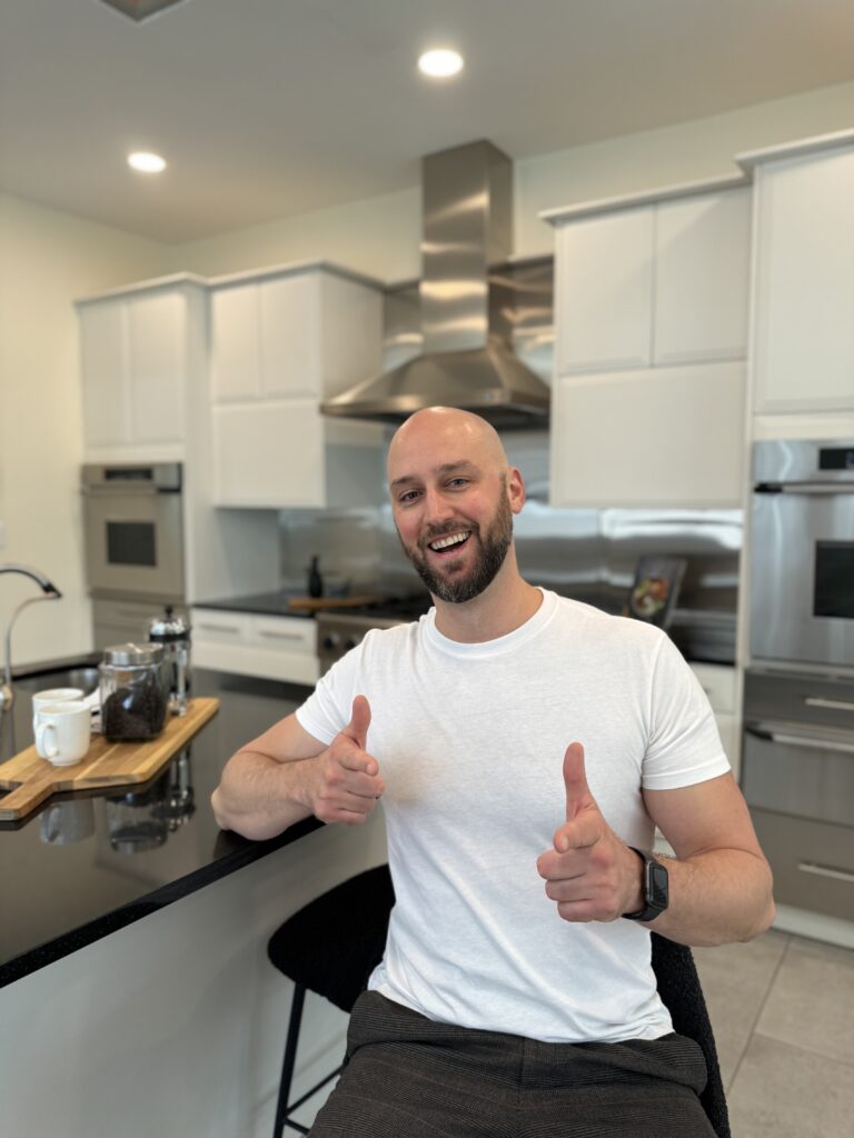 Dan sitting in Kitchen with smile.